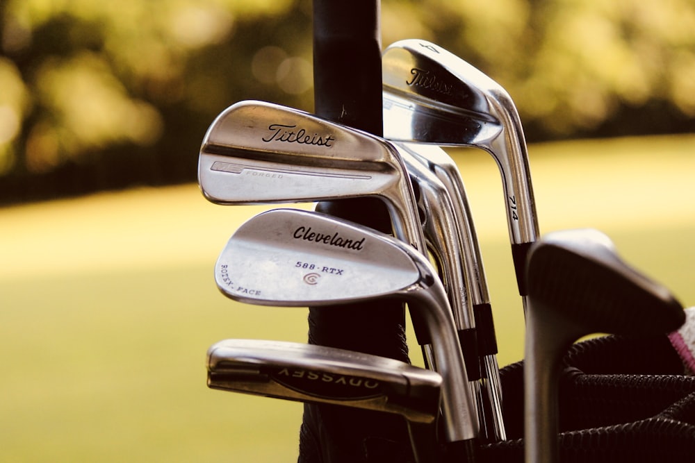 Irons and a putter standing in a golf bag on the fairway