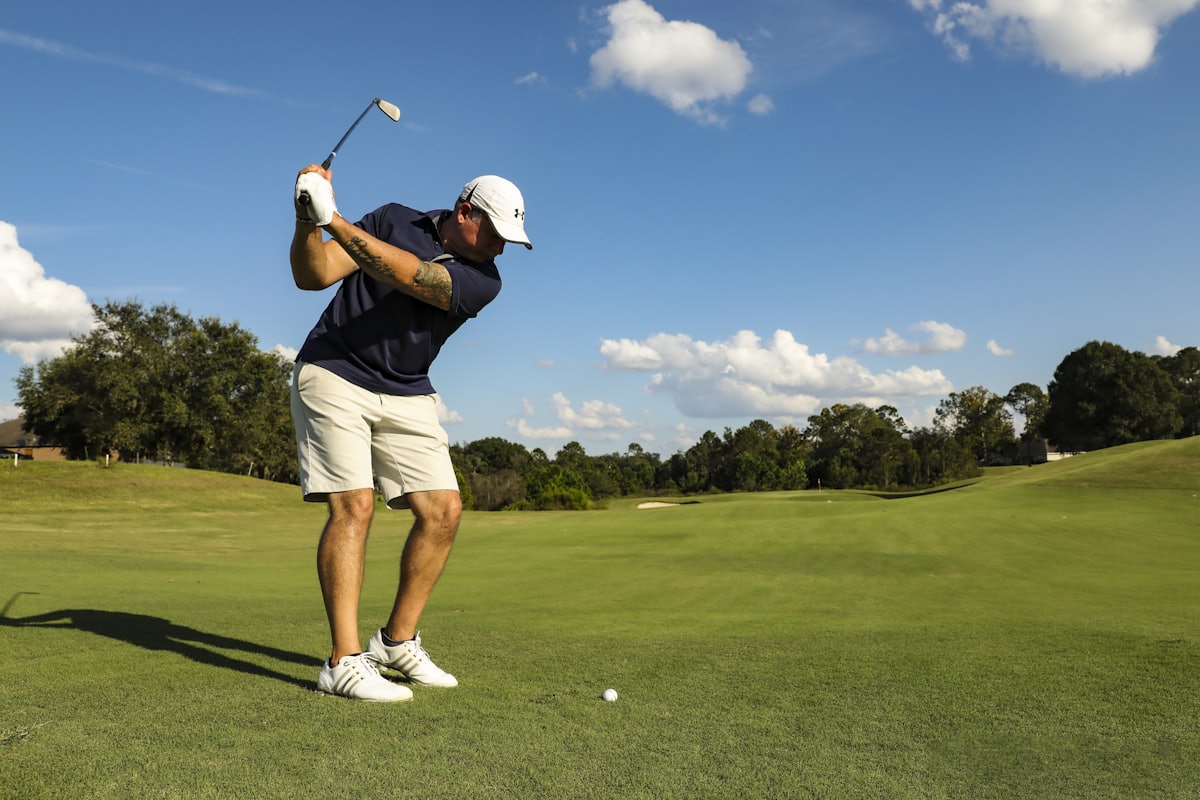A golfer at the top of the backswing on the fairway