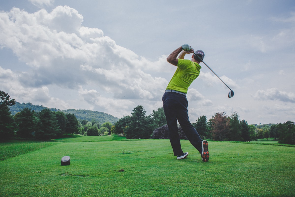 A golfer finishing a drive from an elevated tee